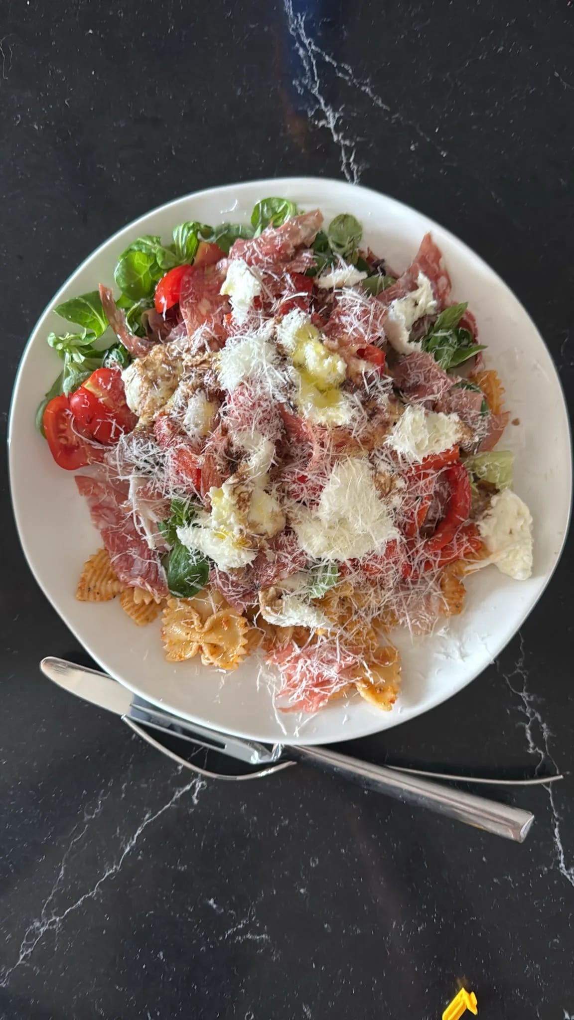 Italiaanse pastasalade met salami, mozzarella en rode pesto